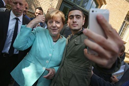 عکس خبري -جوان سوريه‌اي که با صدراعظم آلمان سلفي گرفت فيس‌بوک را به دادگاه کشاند